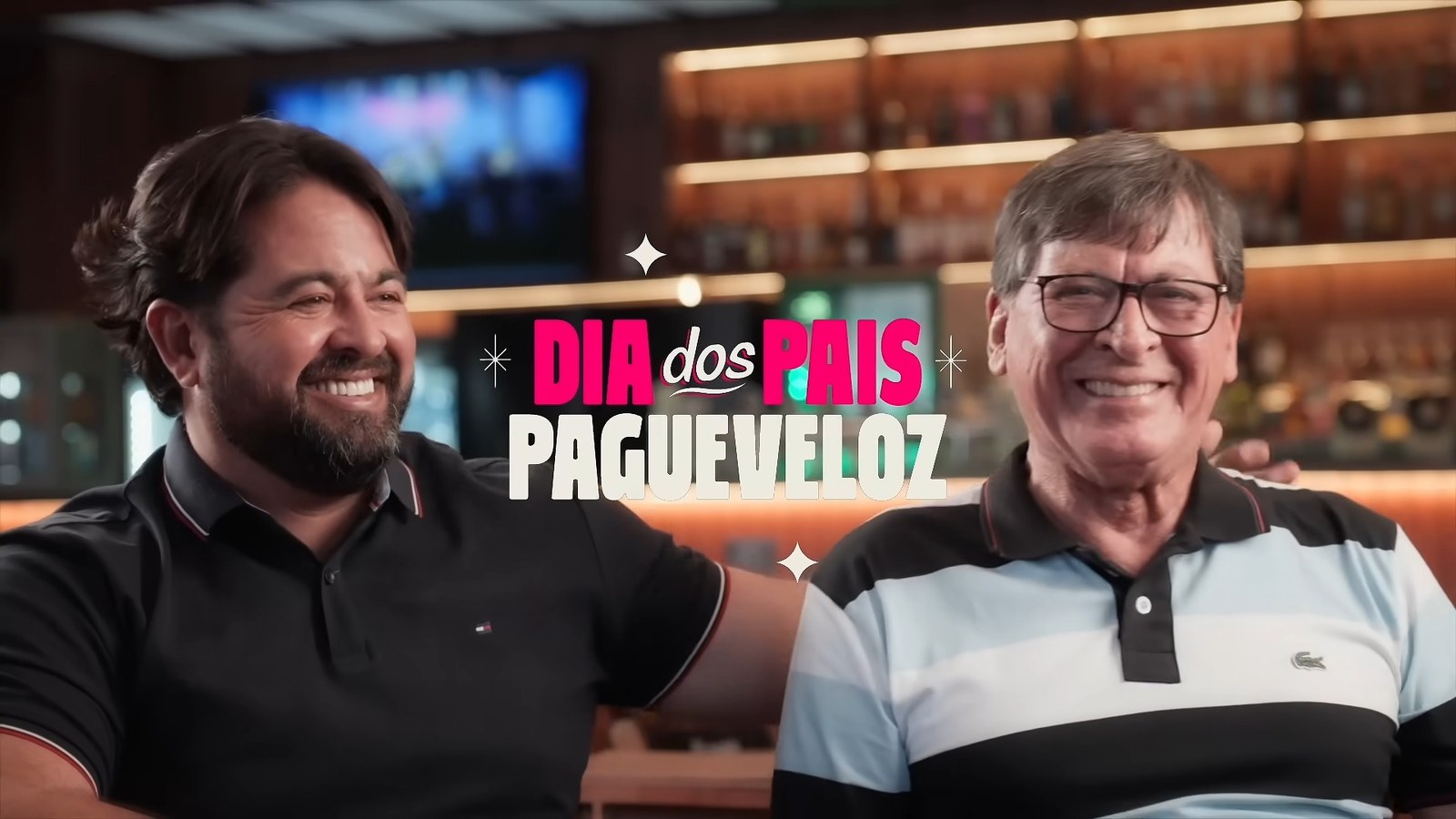 Dois protagonistas reais da campanha sorrindo lado a lado, com o letreiro "Dia dos Pais PagueVeloz" sobreposto